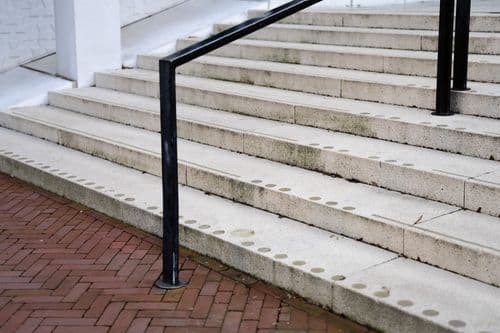 Contrasterende donkerbruine trapleuning trap bordes buitenkans Huis der Provincie